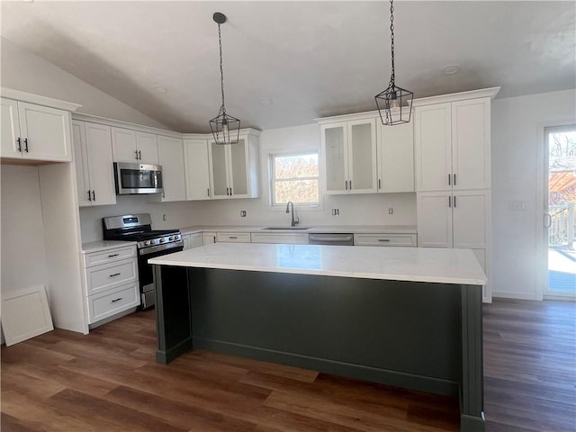 kitchen with white cabinetry, appliances with stainless steel finishes, a kitchen island, and pendant lighting