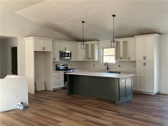 kitchen with stainless steel appliances, hanging light fixtures, a center island, and white cabinets