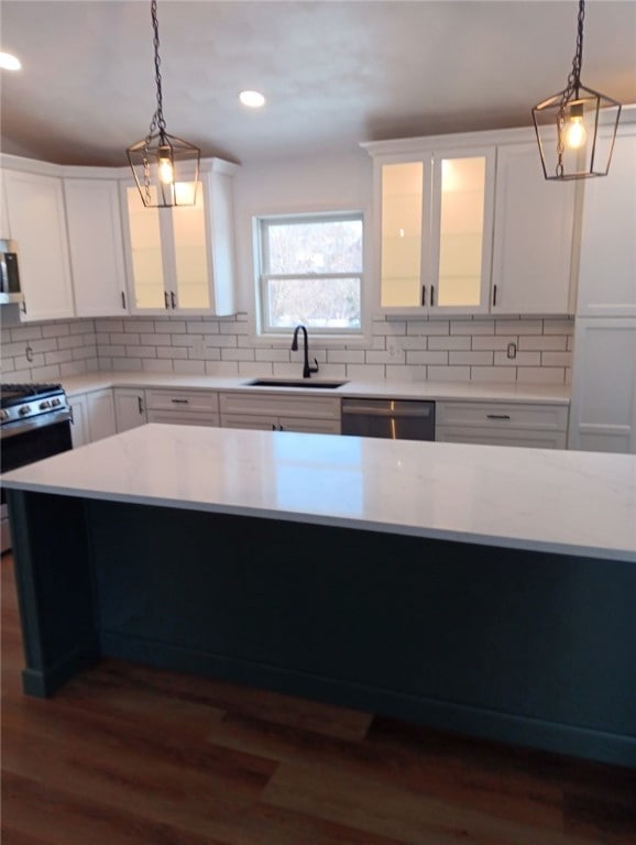 kitchen with hanging light fixtures, white cabinetry, and appliances with stainless steel finishes