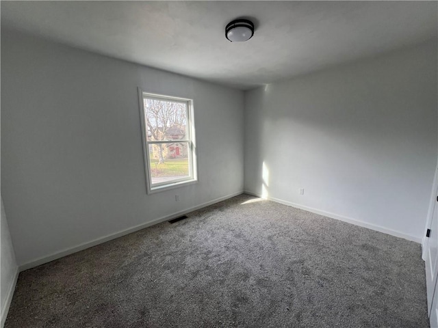 unfurnished room with dark colored carpet