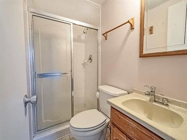 bathroom featuring tile patterned flooring, vanity, toilet, and a shower with shower door