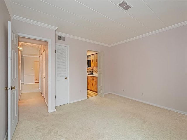 unfurnished bedroom featuring ensuite bathroom, light colored carpet, crown molding, and a closet