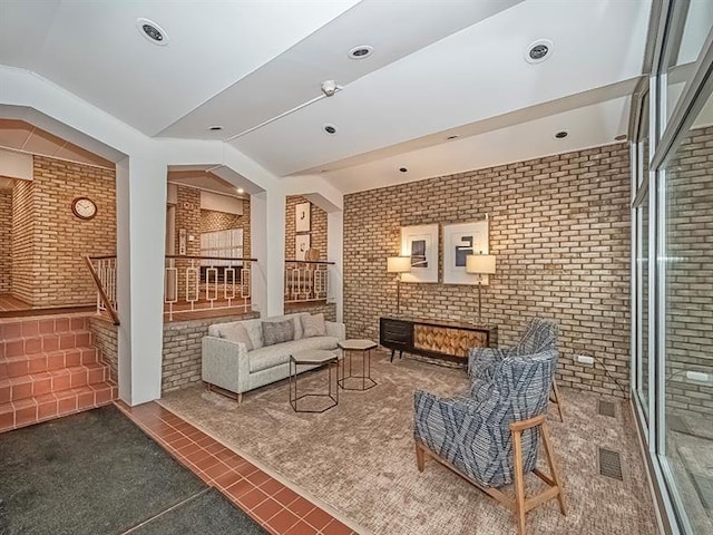 sitting room with brick wall and vaulted ceiling