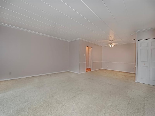 carpeted spare room with ceiling fan and crown molding