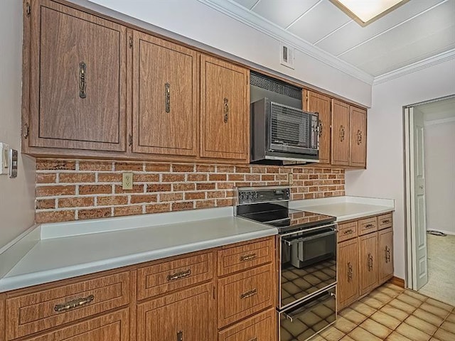 kitchen featuring light tile patterned floors, ornamental molding, and black appliances