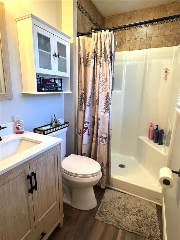 bathroom with a shower with curtain, vanity, toilet, and hardwood / wood-style floors