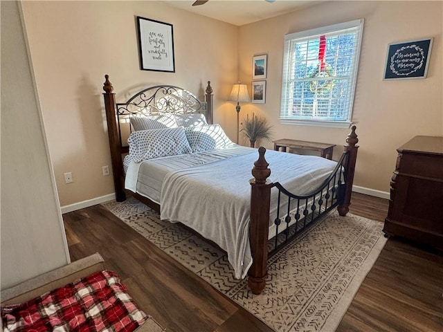 bedroom with dark hardwood / wood-style flooring and ceiling fan