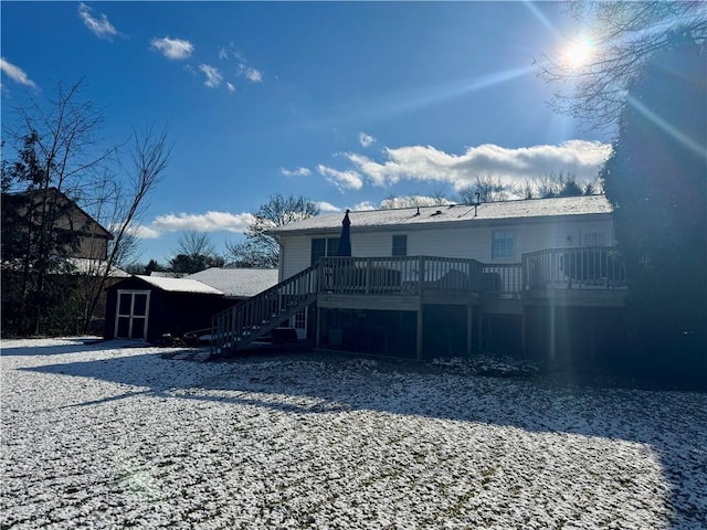 back of property with a deck and a storage unit