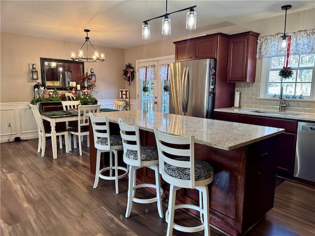 kitchen with pendant lighting, a chandelier, plenty of natural light, and stainless steel appliances