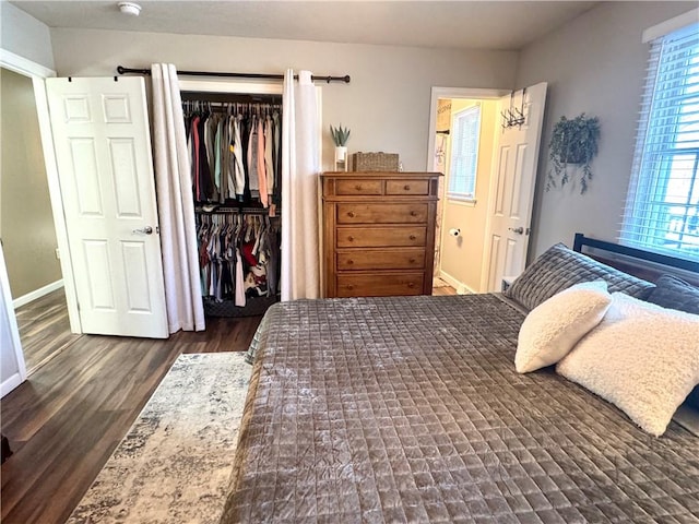 bedroom with dark hardwood / wood-style floors and a closet