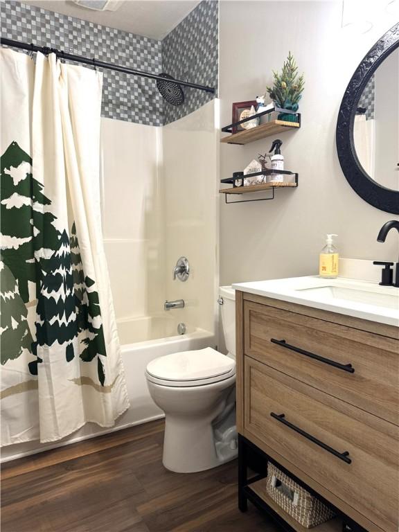 full bathroom with hardwood / wood-style floors, shower / bath combination with curtain, toilet, and vanity