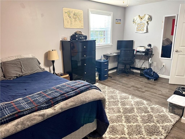 bedroom with dark hardwood / wood-style flooring