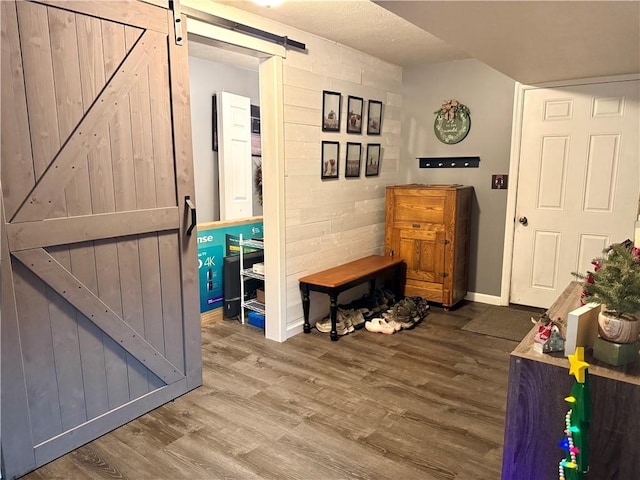 interior space with a barn door and wood-type flooring