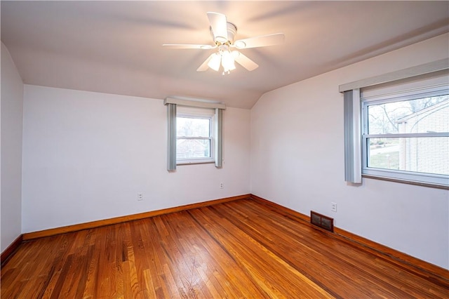 empty room featuring hardwood / wood-style flooring, ceiling fan, and lofted ceiling