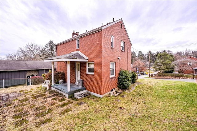 rear view of property with a lawn