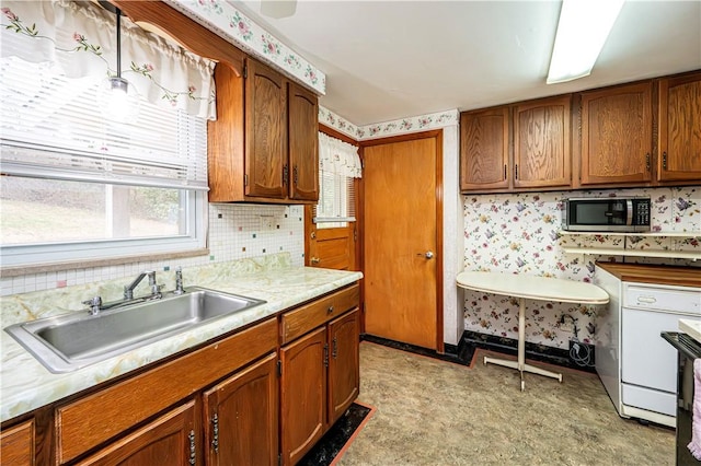 kitchen with decorative backsplash, sink, and white dishwasher