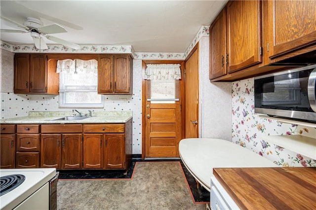 kitchen with decorative backsplash, ceiling fan, and sink