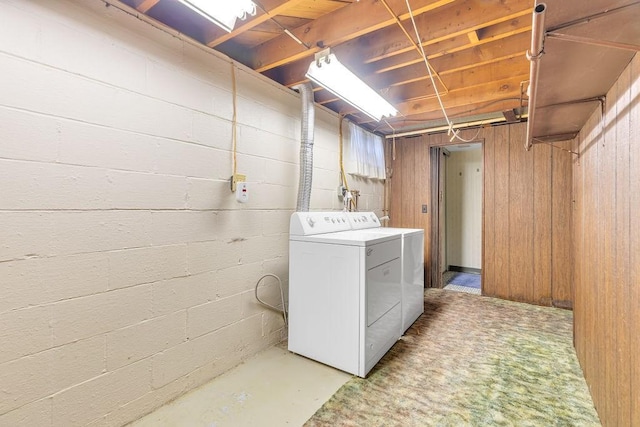 washroom featuring washer and dryer and wooden walls