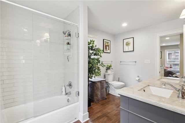 full bathroom with wood-type flooring, vanity, toilet, and tiled shower / bath combo