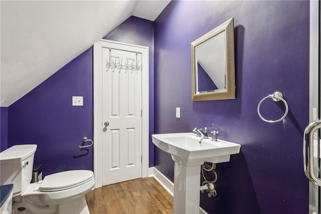 bathroom featuring wood-type flooring, lofted ceiling, and toilet