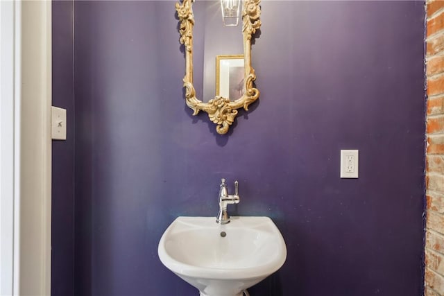 bathroom with sink and brick wall