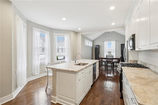 kitchen featuring white cabinetry, a center island with sink, a healthy amount of sunlight, and sink