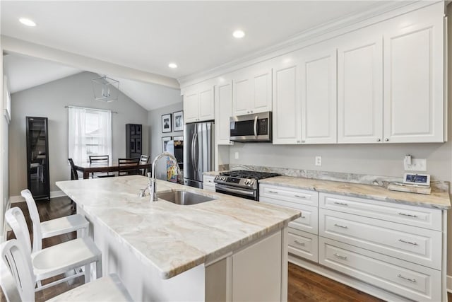 kitchen featuring appliances with stainless steel finishes, a center island with sink, lofted ceiling, and sink