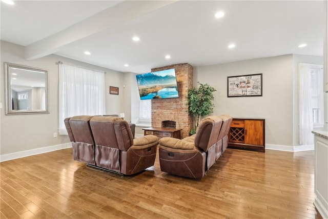 living room with beam ceiling and light wood-type flooring