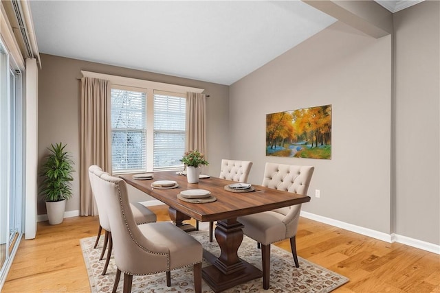 dining space with light hardwood / wood-style floors and lofted ceiling