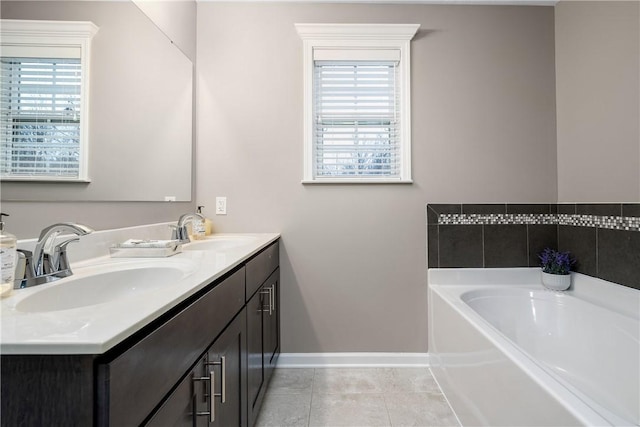 bathroom featuring tile patterned flooring, plenty of natural light, a tub, and vanity