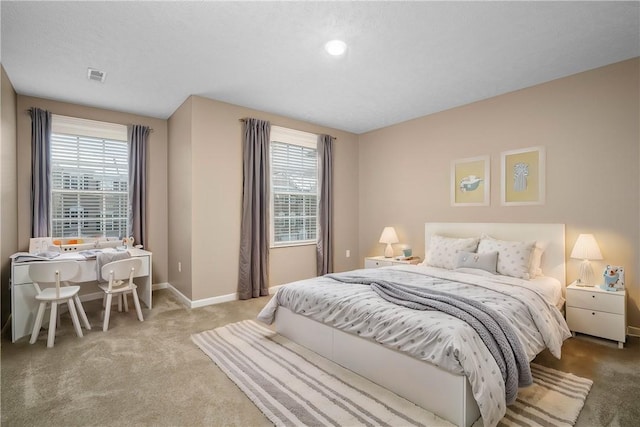 carpeted bedroom with a textured ceiling and multiple windows