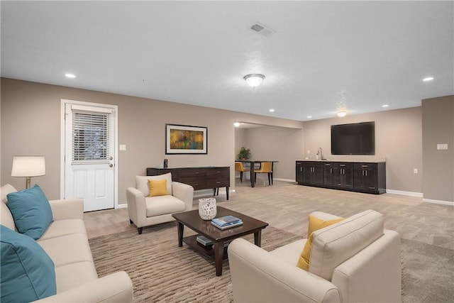 carpeted living room featuring sink