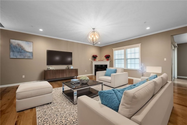 living room with crown molding, light hardwood / wood-style flooring, and a notable chandelier