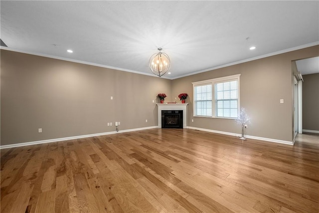 unfurnished living room with light wood-type flooring, an inviting chandelier, and ornamental molding