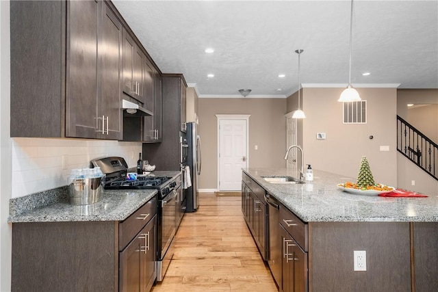 kitchen featuring sink, stainless steel appliances, light stone counters, light hardwood / wood-style flooring, and pendant lighting