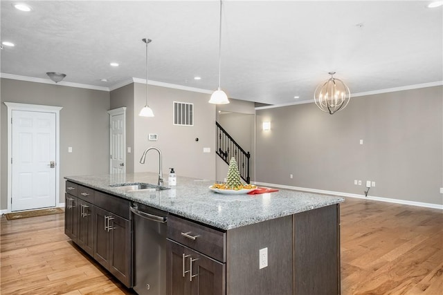 kitchen featuring stainless steel dishwasher, pendant lighting, light wood-type flooring, and a kitchen island with sink