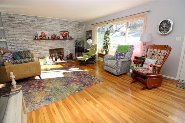 living room with light hardwood / wood-style floors and a brick fireplace