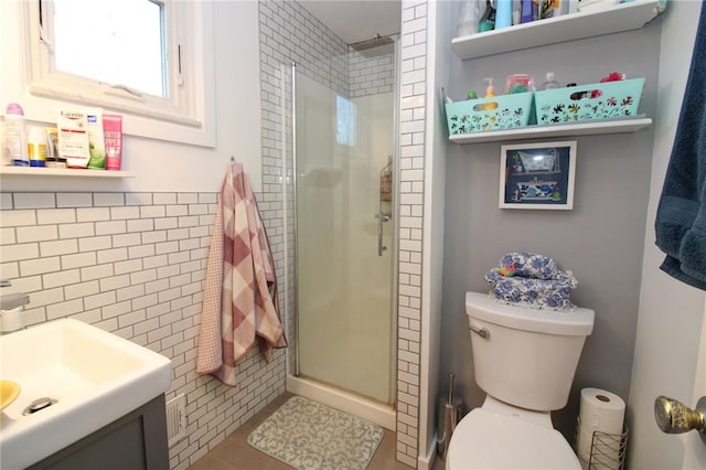 bathroom with an enclosed shower, vanity, toilet, and tile walls