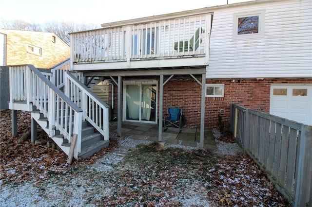 back of house with a garage, a patio, and a wooden deck