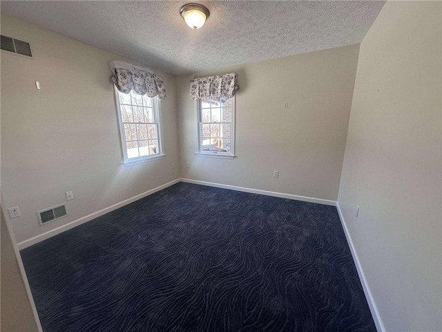 carpeted spare room featuring a textured ceiling