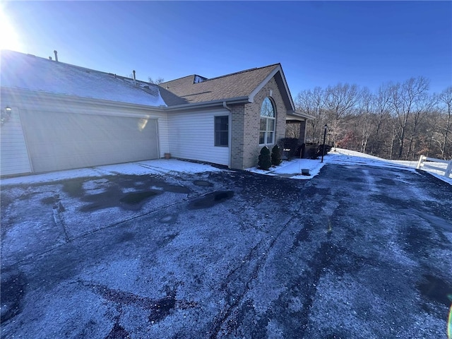 view of snowy exterior featuring a garage