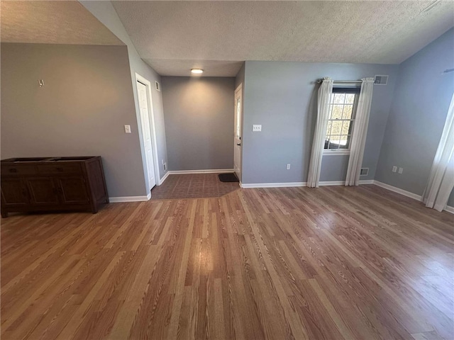 interior space with wood-type flooring and a textured ceiling