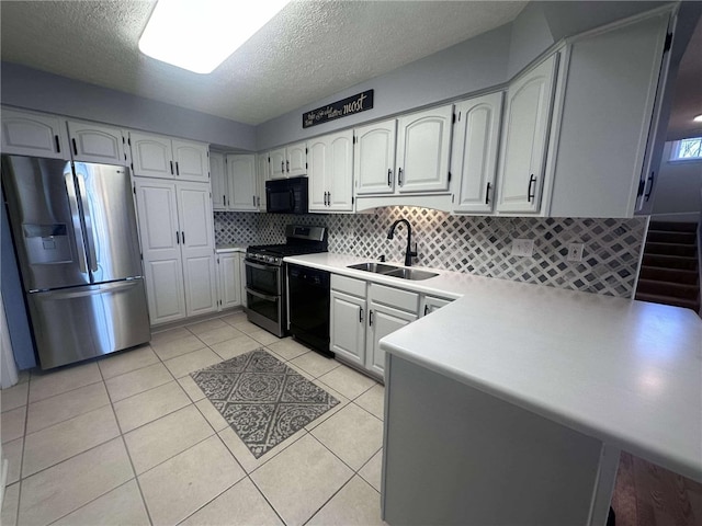 kitchen featuring backsplash, sink, black appliances, light tile patterned floors, and white cabinets