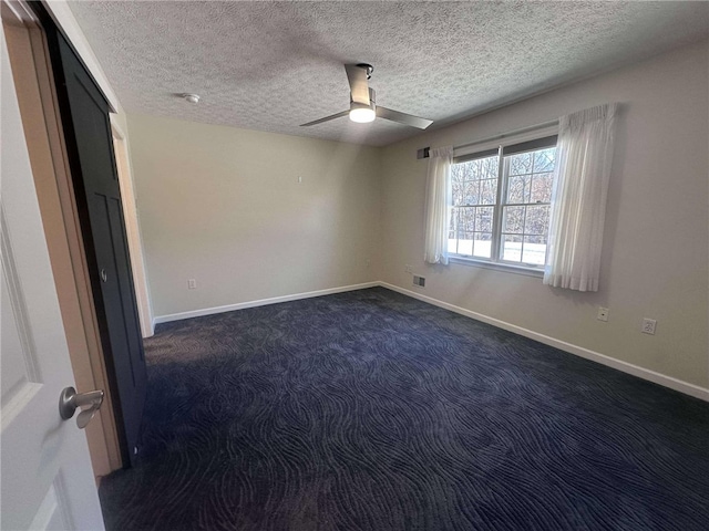 carpeted spare room with a textured ceiling and ceiling fan