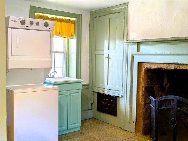 clothes washing area featuring sink and stacked washer / dryer