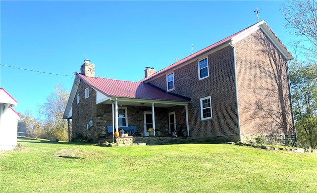 rear view of property with a lawn