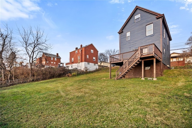 back of property with a deck and a yard