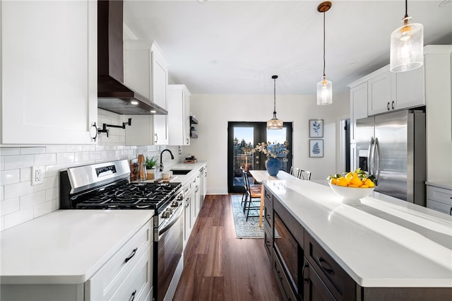 1940 Warriors Rd, Banksville/Westwood, PA 15205 - kitchen featuring stainless steel appliances, wall chimney range hood, dark wood-style floors, decorative backsplash, and light countertops