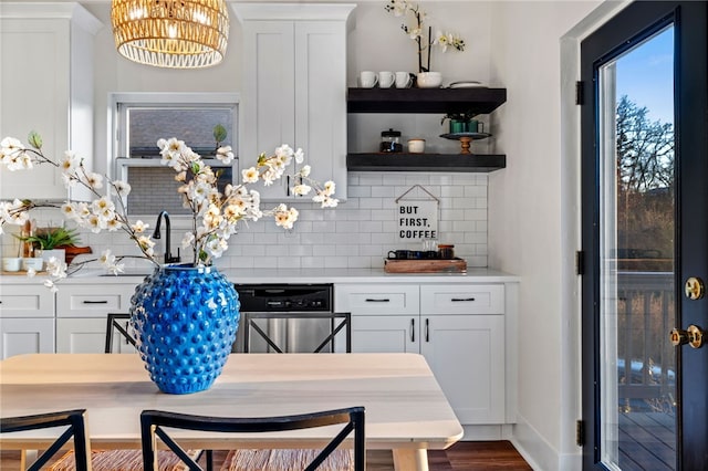 bar featuring backsplash, white cabinets, sink, hardwood / wood-style flooring, and a notable chandelier