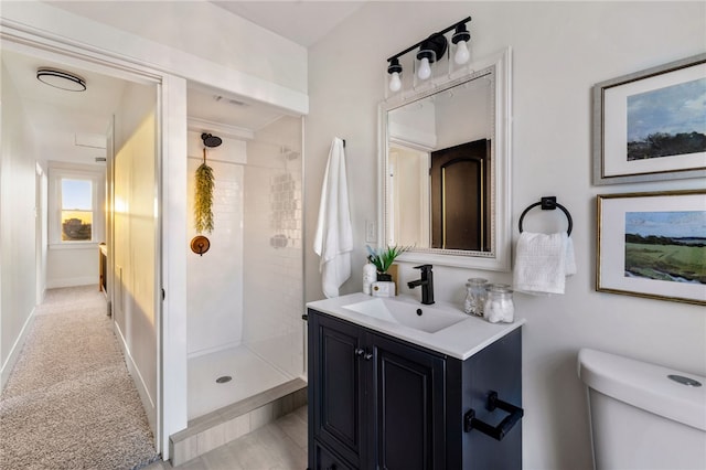 bathroom featuring vanity, toilet, and tiled shower